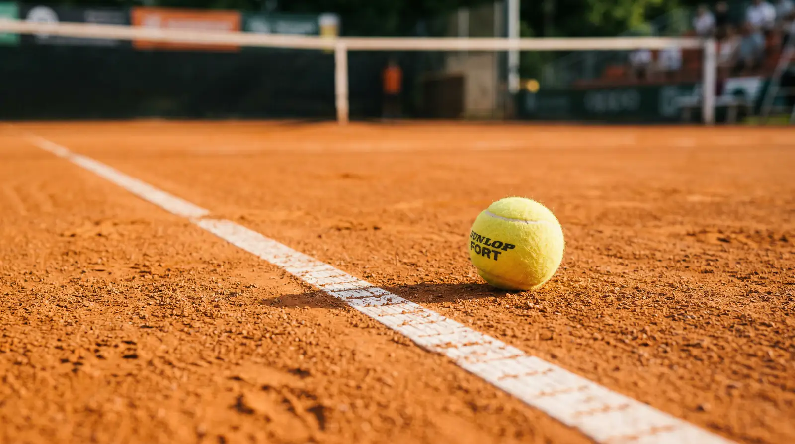 Tennisball neben der Linie auf Sandplatz – Fehler bei Tenniswetten vermeiden